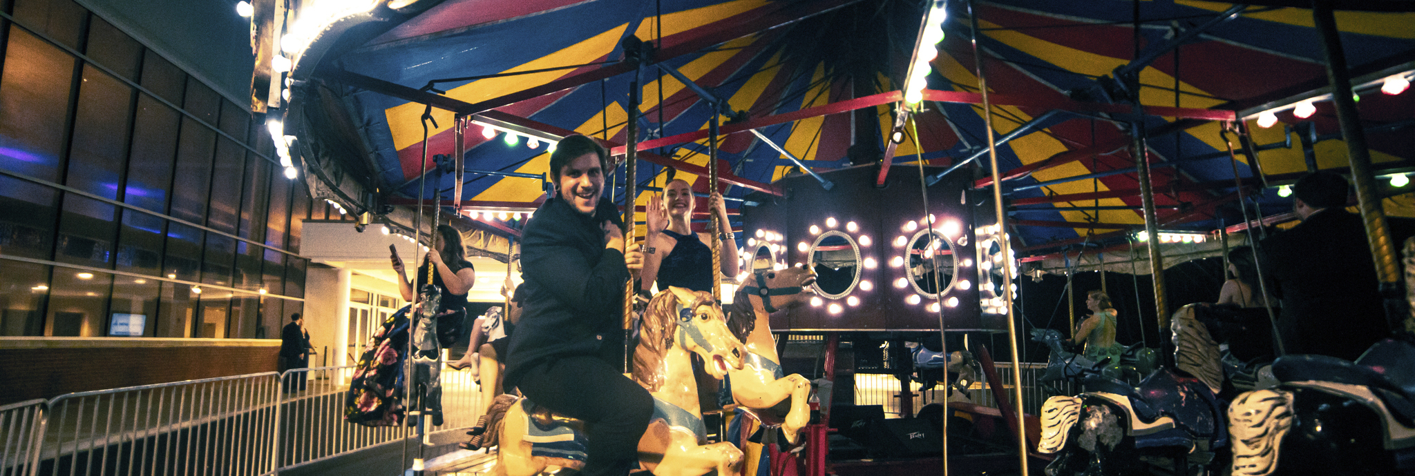 Patrons riding a Carousel at The Willows